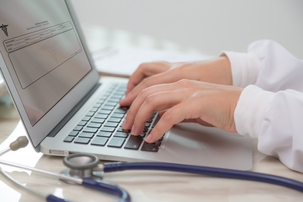 Doctor hands typing on laptop keyboard